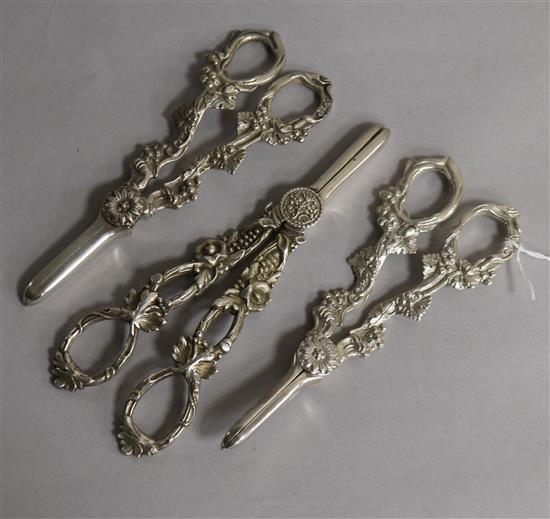 A pair of modern silver grape shears and two pairs of silver plated grape shears.